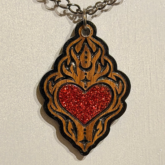Handcrafted sacred heart necklace with ornate black detailing and red glitter resin accent