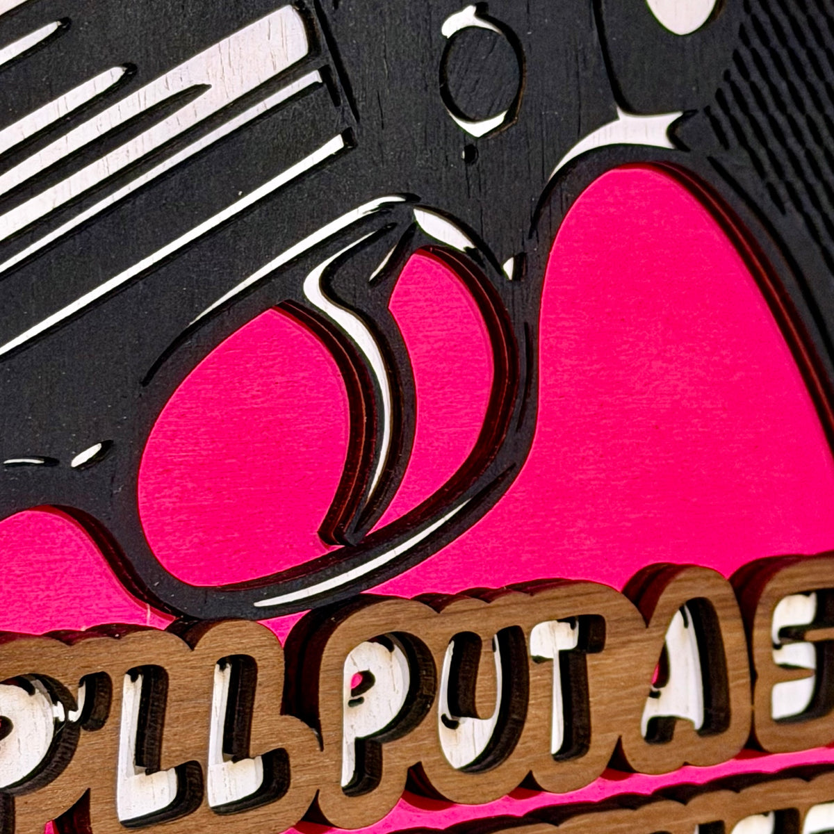 Close-up detail of layered revolver artwork and raised wooden lettering