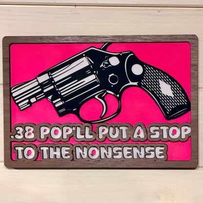 Front view of hot pink layered wooden revolver wall sign