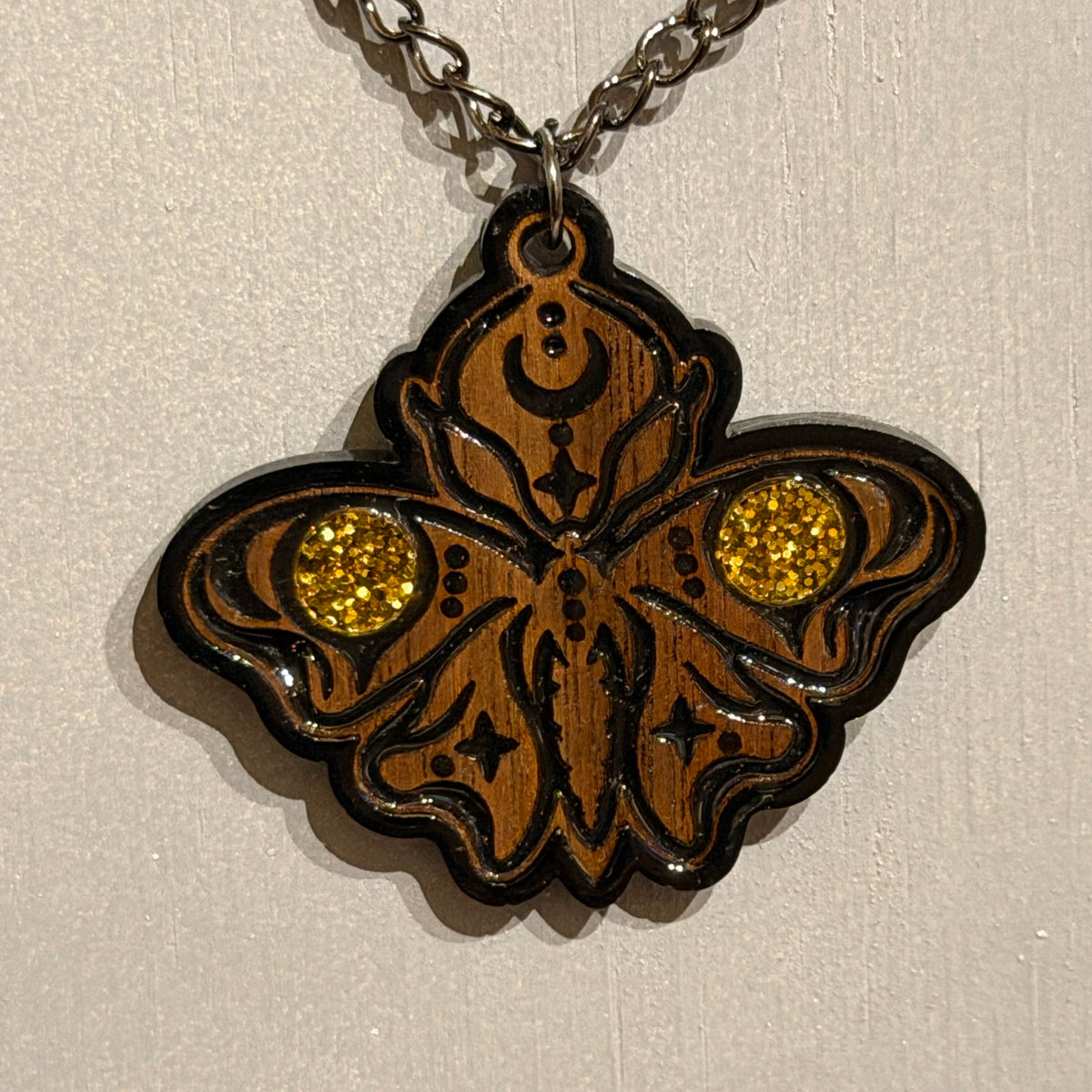 Sanctum Hex gothic moth pendant showing celestial details and curved black engraved lines
