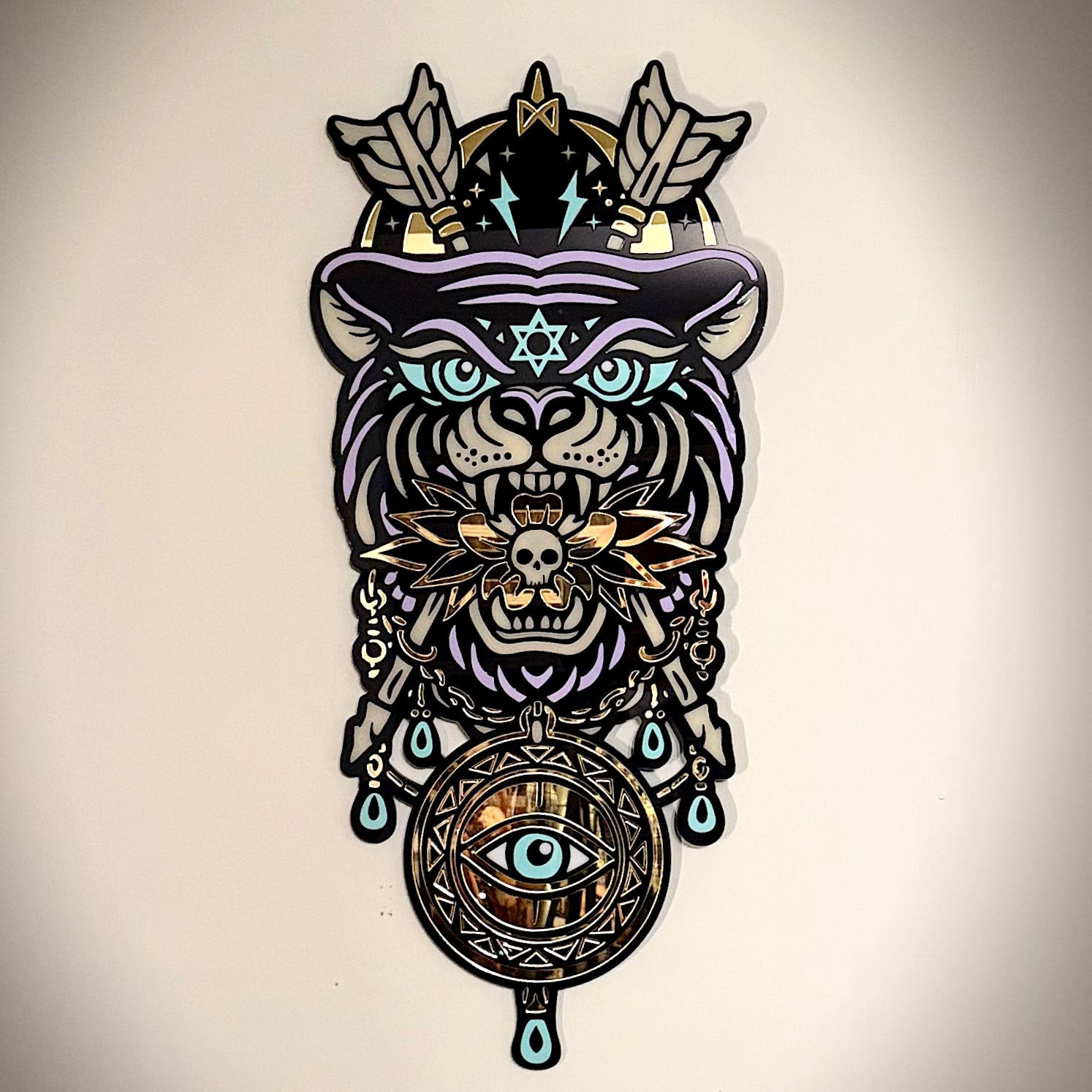 Decorative wall art with a stylized animal head design featuring symbols and patterns on a beige background.