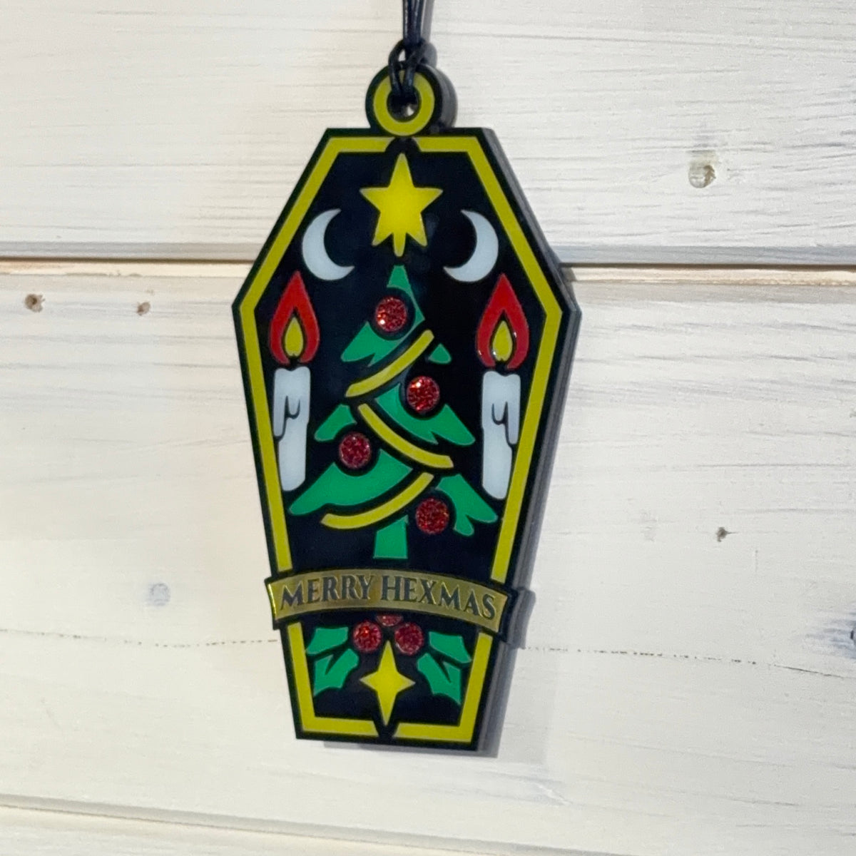 Angled view of Merry Hexmas coffin ornament showing layered construction