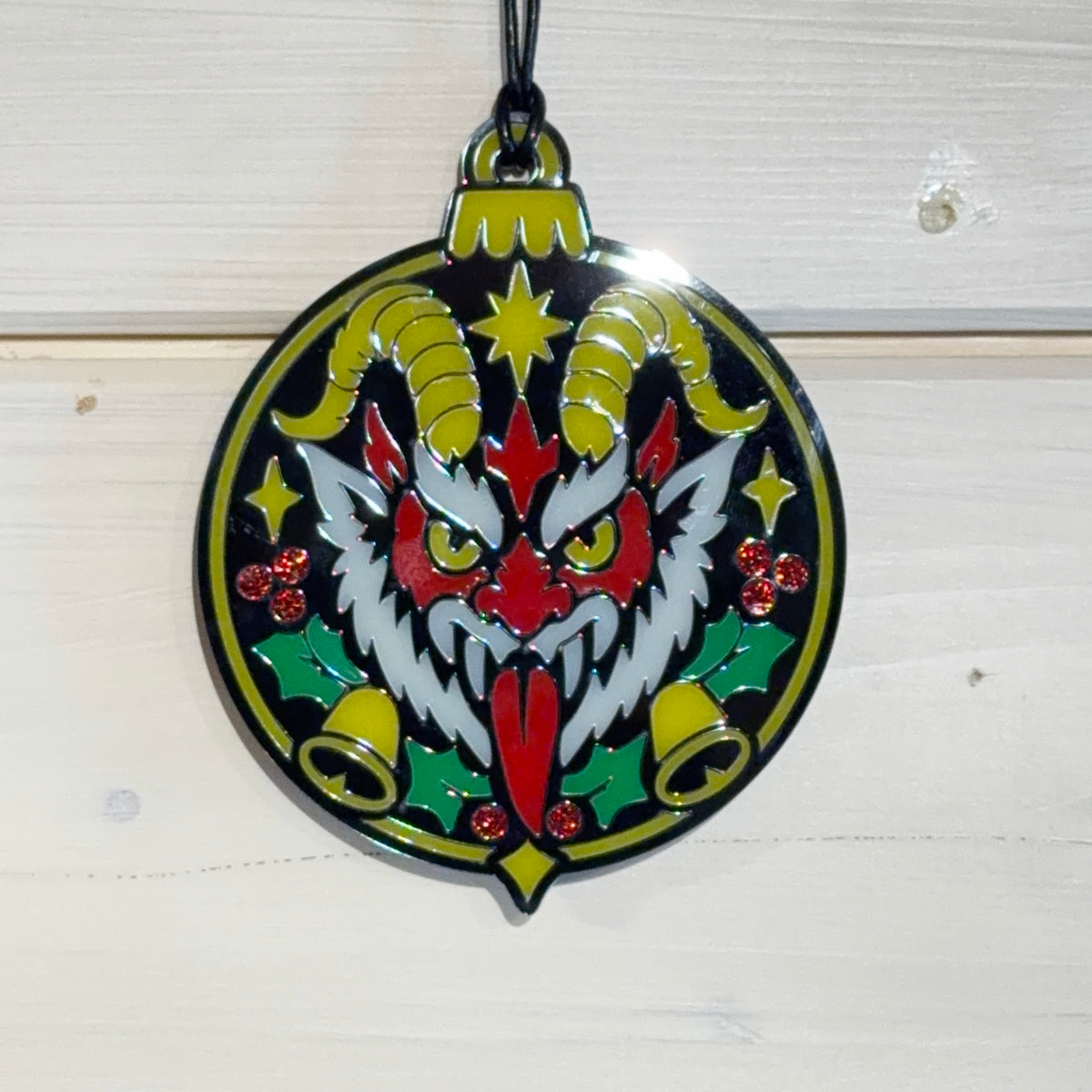 Front detail view of Merry Hexmas Krampus ornament with holly, bells and glitter berries