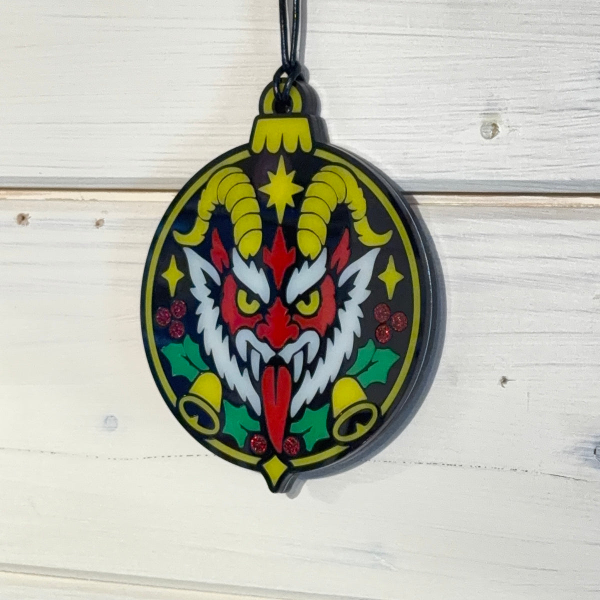 Merry Hexmas Krampus ornament hanging against a white timber background