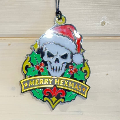 Front view of Merry Hexmas Santa Skull ornament hanging against a white timber background