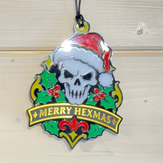 Front view of Merry Hexmas Santa Skull ornament hanging against a white timber background